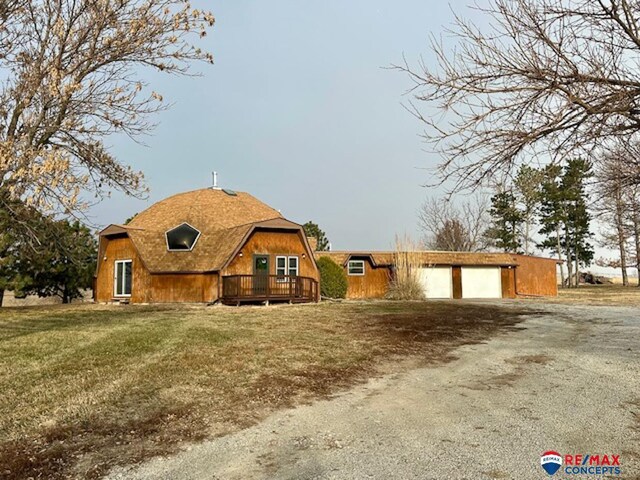17200 Pella Rd, Adams, NE 68301 - view of front of home with a wooden deck, dirt driveway, a gambrel roof, a front yard, and a detached garage