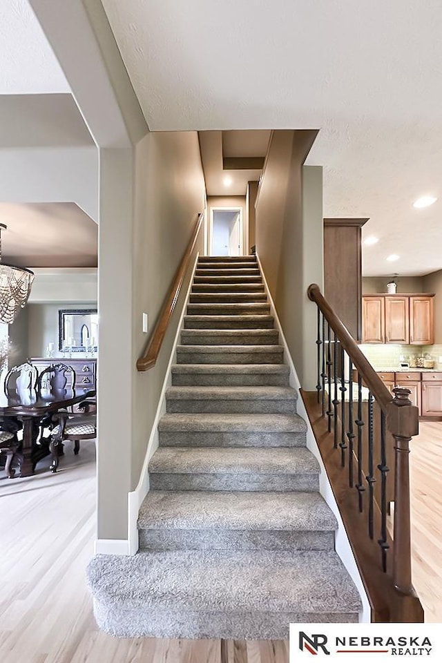 stairway featuring wood finished floors and baseboards
