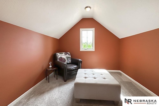 living area with carpet floors, lofted ceiling, and baseboards