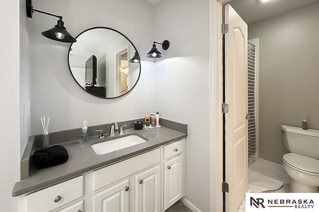 bathroom featuring toilet, vanity, baseboards, and tile patterned flooring