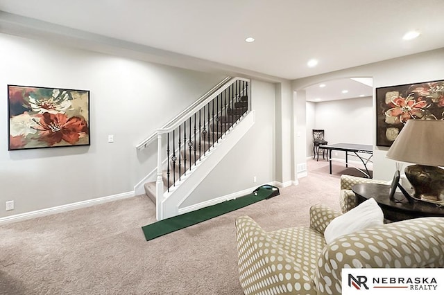 living area with carpet floors, recessed lighting, arched walkways, stairs, and baseboards
