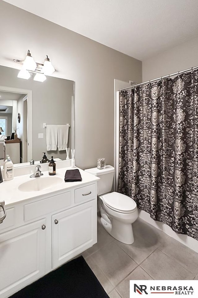 full bathroom featuring tile patterned floors, toilet, vanity, and curtained shower
