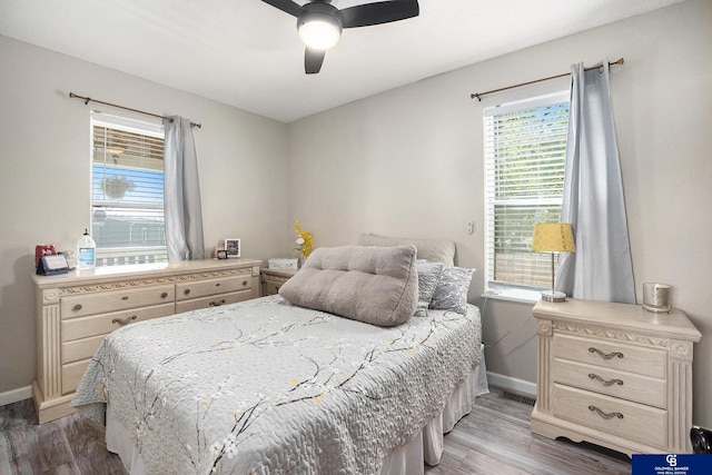 bedroom with baseboards, light wood finished floors, and a ceiling fan