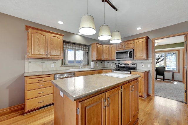 4630 Eagle Ridge Rd, Lincoln, NE 68516 - kitchen featuring appliances with stainless steel finishes, a sink, light wood-style floors, a center island, and healthy amount of natural light