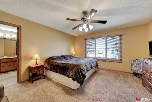 4630 Eagle Ridge Rd, Lincoln, NE 68516 - bedroom with light colored carpet, baseboards, ensuite bath, a ceiling fan, and a textured ceiling
