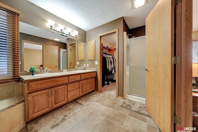 4630 Eagle Ridge Rd, Lincoln, NE 68516 - bathroom with a shower stall, double vanity, a spacious closet, healthy amount of natural light, and a textured ceiling