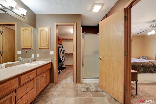 4630 Eagle Ridge Rd, Lincoln, NE 68516 - ensuite bathroom with ceiling fan, a shower stall, vanity, a textured ceiling, and a walk in closet