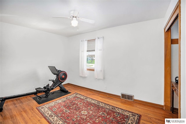 workout room with wood finished floors, ceiling fan, and baseboards