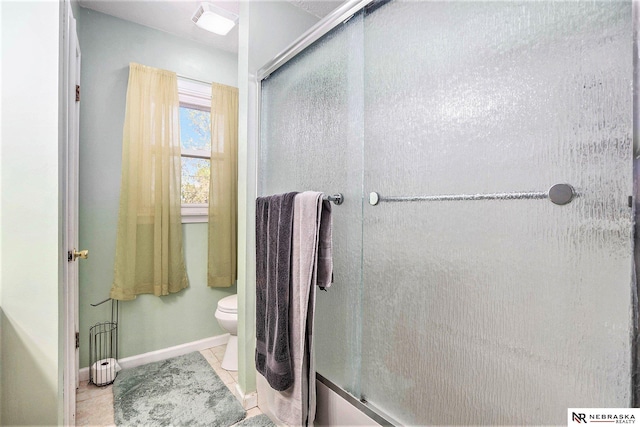 bathroom with a stall shower, toilet, baseboards, and tile patterned floors