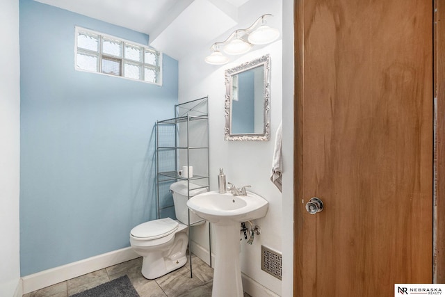 bathroom featuring toilet and baseboards