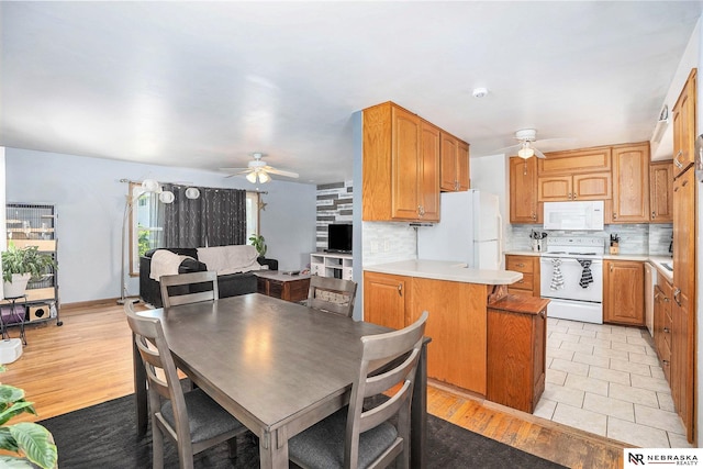 dining room with ceiling fan and light wood-type flooring