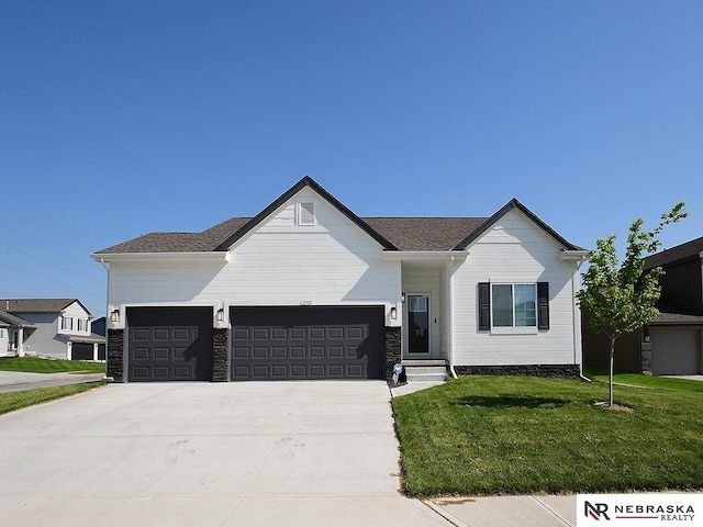view of front of house with an attached garage, a front lawn, and concrete driveway