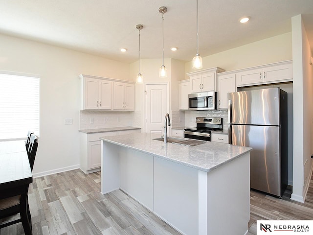 kitchen featuring stainless steel appliances, a sink, decorative backsplash, white cabinetry, and recessed lighting