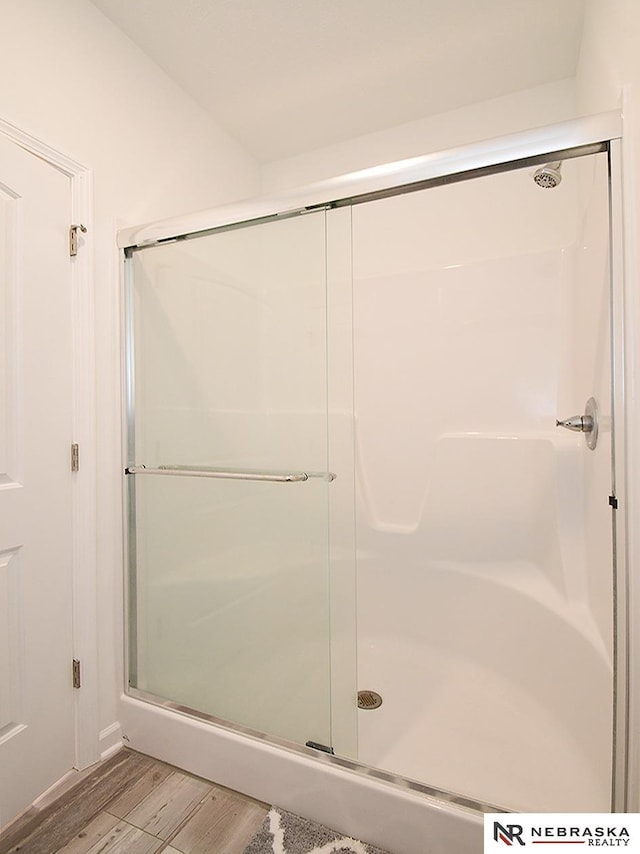 bathroom with a stall shower and wood finished floors