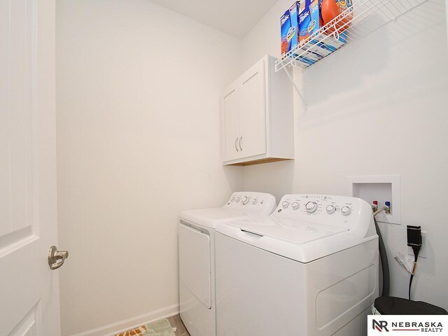 laundry area featuring cabinet space, independent washer and dryer, and baseboards