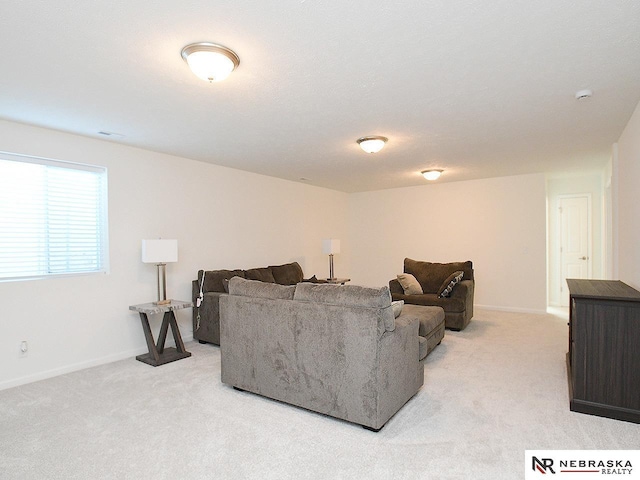living area with light carpet and baseboards
