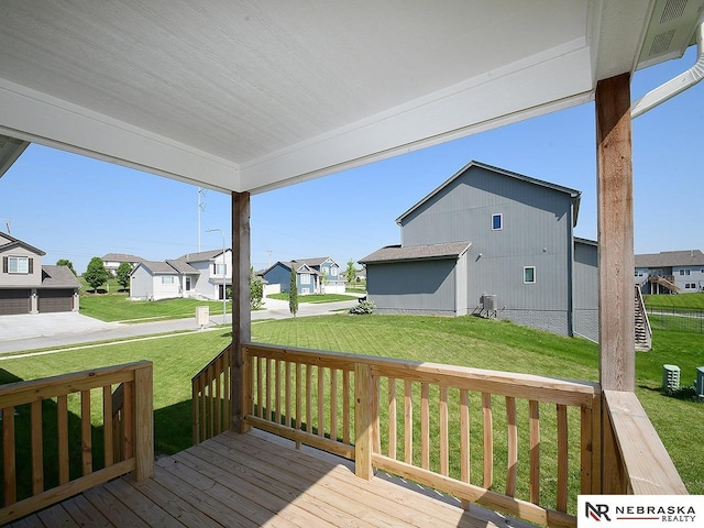 deck with a residential view and a lawn