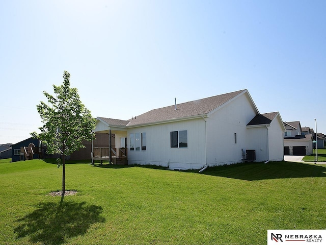 back of property featuring a lawn and central AC unit