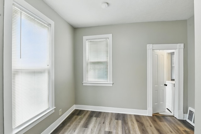 spare room featuring wood finished floors, a smoke detector, and baseboards