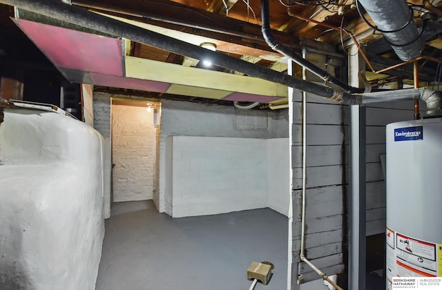 unfinished basement with water heater and oil tank