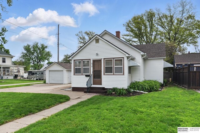 view of front facade featuring entry steps, driveway, an outbuilding, a garage, and a chimney