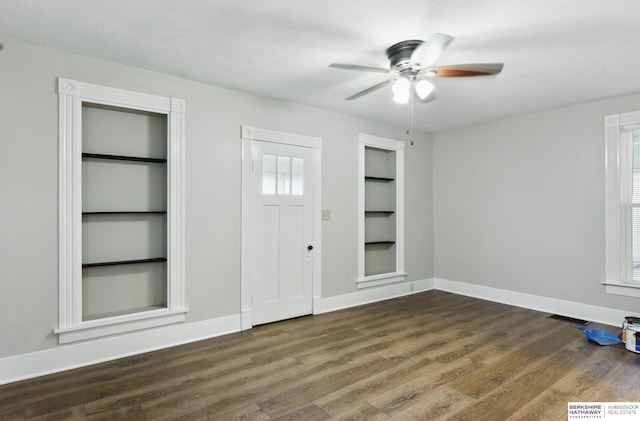 foyer entrance featuring dark wood finished floors, baseboards, and a ceiling fan