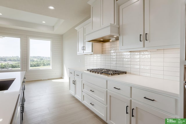 5705 N 197th St, Elkhorn, NE 68022 - kitchen with stainless steel gas stovetop, light wood-type flooring, decorative backsplash, light countertops, and white cabinets