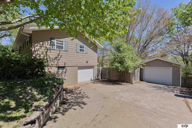 1909 Collins Dr, Bellevue, NE 68005 - view of side of home with driveway, fence, an attached garage, and an outbuilding