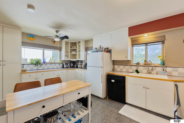 1909 Collins Dr, Bellevue, NE 68005 - kitchen with a sink, freestanding refrigerator, black dishwasher, backsplash, and plenty of natural light