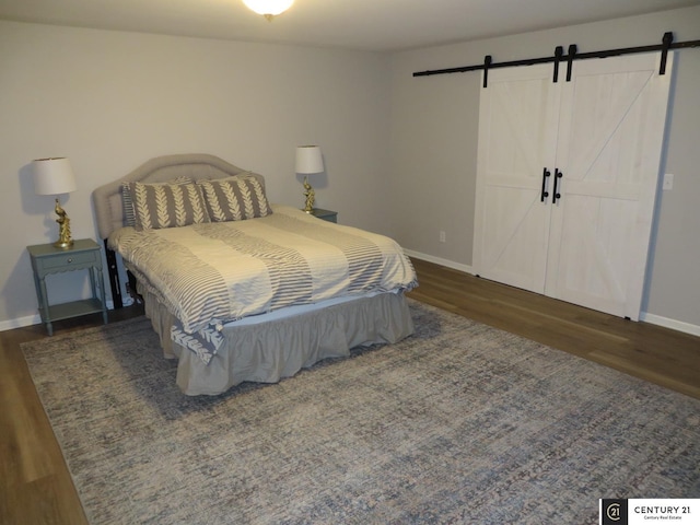 2421 Sand Hills Dr, Papillion, NE 68046 - bedroom featuring a barn door, wood finished floors, and baseboards