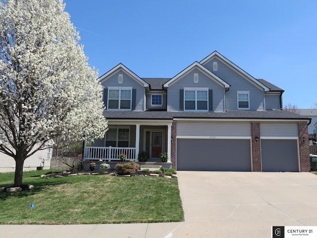 2421 Sand Hills Dr, Papillion, NE 68046 - view of front of home featuring covered porch, concrete driveway, a front yard, brick siding, and a garage