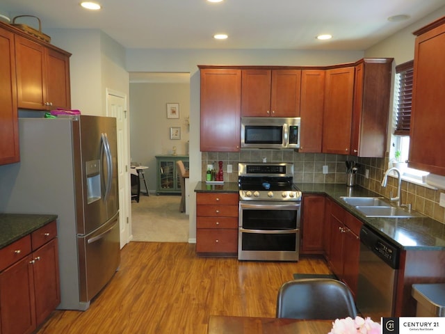 2421 Sand Hills Dr, Papillion, NE 68046 - kitchen with appliances with stainless steel finishes, a sink, light wood-style flooring, backsplash, and recessed lighting
