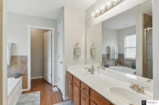 2421 Sand Hills Dr, Papillion, NE 68046 - bathroom featuring double vanity, wood finished floors, a bath, and an enclosed shower