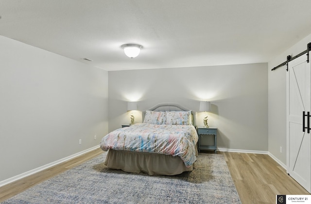 2421 Sand Hills Dr, Papillion, NE 68046 - bedroom with a barn door, wood finished floors, and baseboards