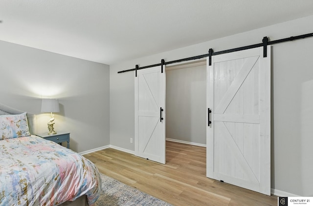 2421 Sand Hills Dr, Papillion, NE 68046 - bedroom with a barn door, light wood-style floors, and baseboards