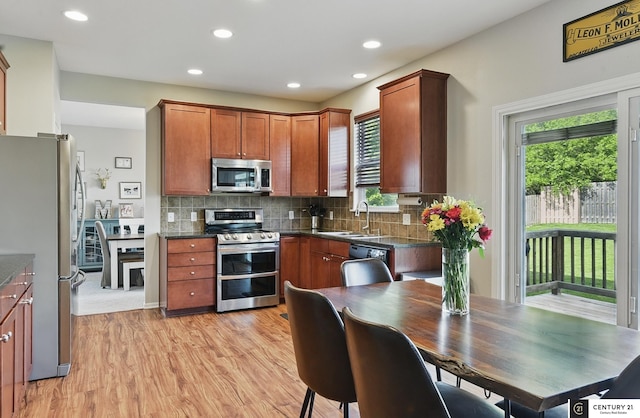 2421 Sand Hills Dr, Papillion, NE 68046 - kitchen featuring stainless steel appliances, a sink, light wood-style floors, decorative backsplash, and recessed lighting