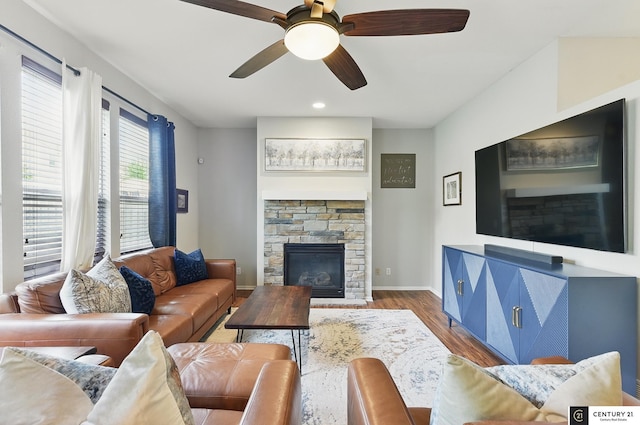 2421 Sand Hills Dr, Papillion, NE 68046 - living area featuring wood finished floors, a stone fireplace, ceiling fan, and baseboards