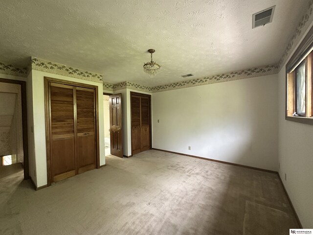 1605 S 113th Plz, Omaha, NE 68144 - unfurnished bedroom featuring two closets, light colored carpet, a textured ceiling, and baseboards