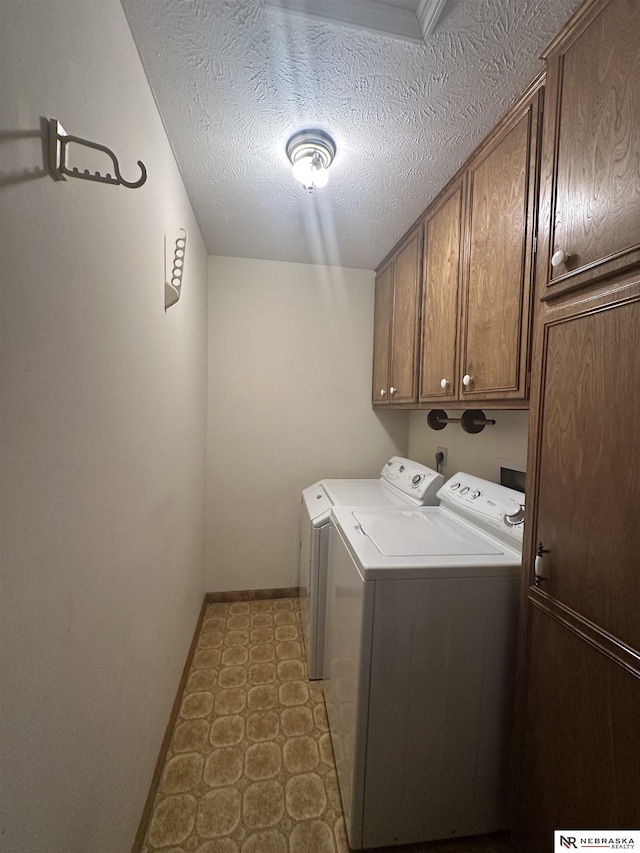 1605 S 113th Plz, Omaha, NE 68144 - clothes washing area featuring cabinet space, washer and clothes dryer, baseboards, a textured ceiling, and tile patterned floors