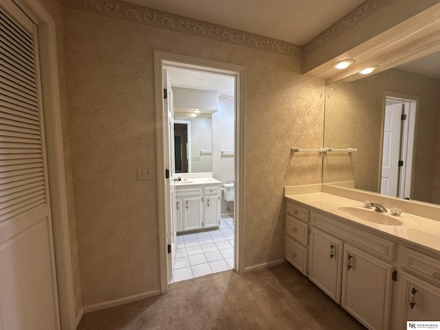 1605 S 113th Plz, Omaha, NE 68144 - bathroom with two vanities, baseboards, toilet, and tile patterned floors