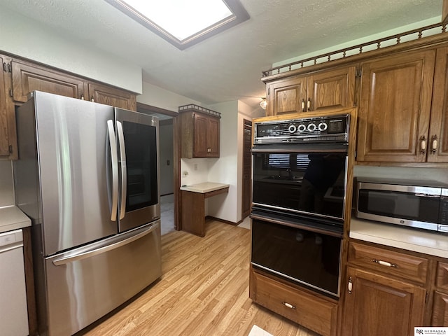 1605 S 113th Plz, Omaha, NE 68144 - kitchen with appliances with stainless steel finishes, light wood-style flooring, light countertops, and brown cabinets