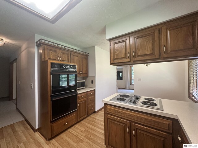 1605 S 113th Plz, Omaha, NE 68144 - kitchen with stainless steel appliances, light countertops, light wood-type flooring, and a textured ceiling