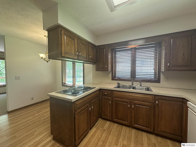1605 S 113th Plz, Omaha, NE 68144 - kitchen with stainless steel electric cooktop, a peninsula, light wood finished floors, light countertops, and a textured ceiling