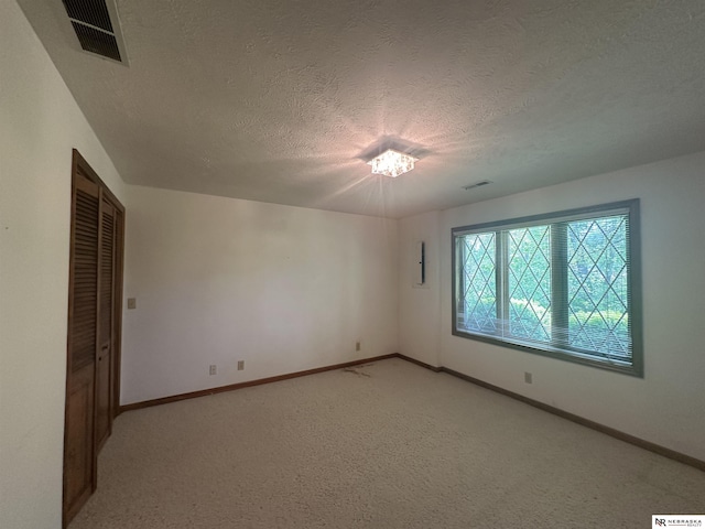 1605 S 113th Plz, Omaha, NE 68144 - unfurnished bedroom with a textured ceiling, baseboards, light colored carpet, and a chandelier