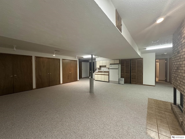 1605 S 113th Plz, Omaha, NE 68144 - finished below grade area featuring freestanding refrigerator, a fireplace, a textured ceiling, brick wall, and light carpet