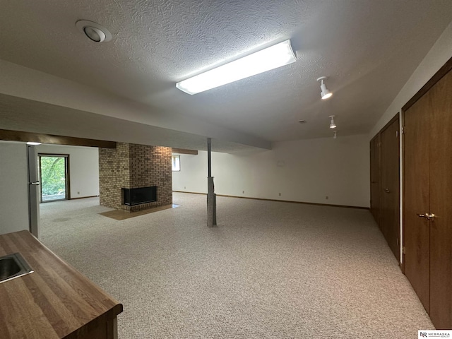 1605 S 113th Plz, Omaha, NE 68144 - below grade area featuring a brick fireplace, a textured ceiling, light carpet, freestanding refrigerator, and baseboards