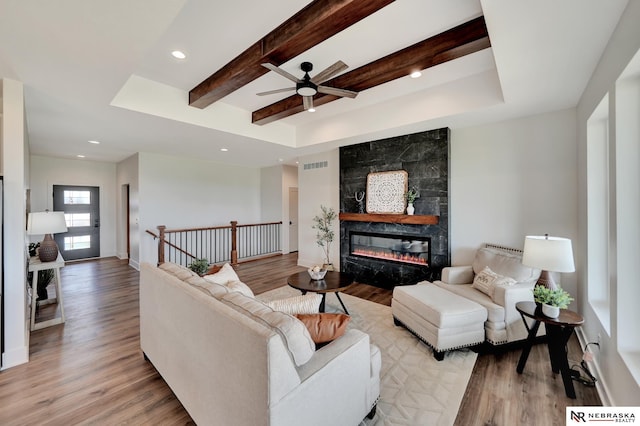 612 N 107th St, Lincoln, NE 68527 - living room with a ceiling fan, light wood-style floors, beam ceiling, a tile fireplace, and recessed lighting