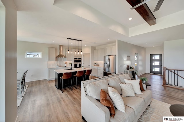 612 N 107th St, Lincoln, NE 68527 - living room featuring light wood-type flooring, baseboards, recessed lighting, and beam ceiling