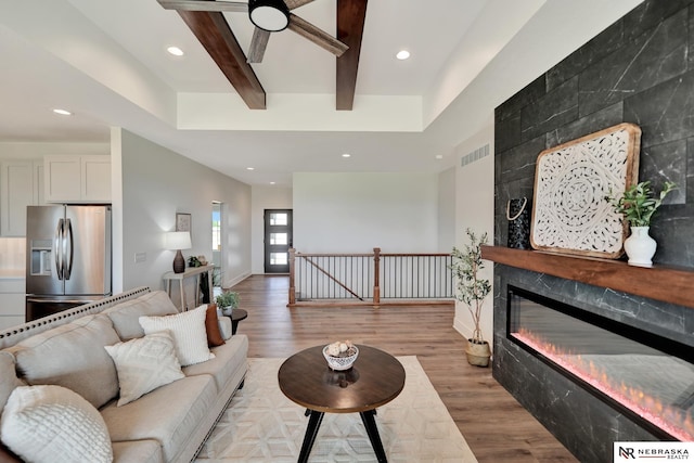 612 N 107th St, Lincoln, NE 68527 - living area featuring light wood-type flooring, a large fireplace, beamed ceiling, recessed lighting, and a ceiling fan