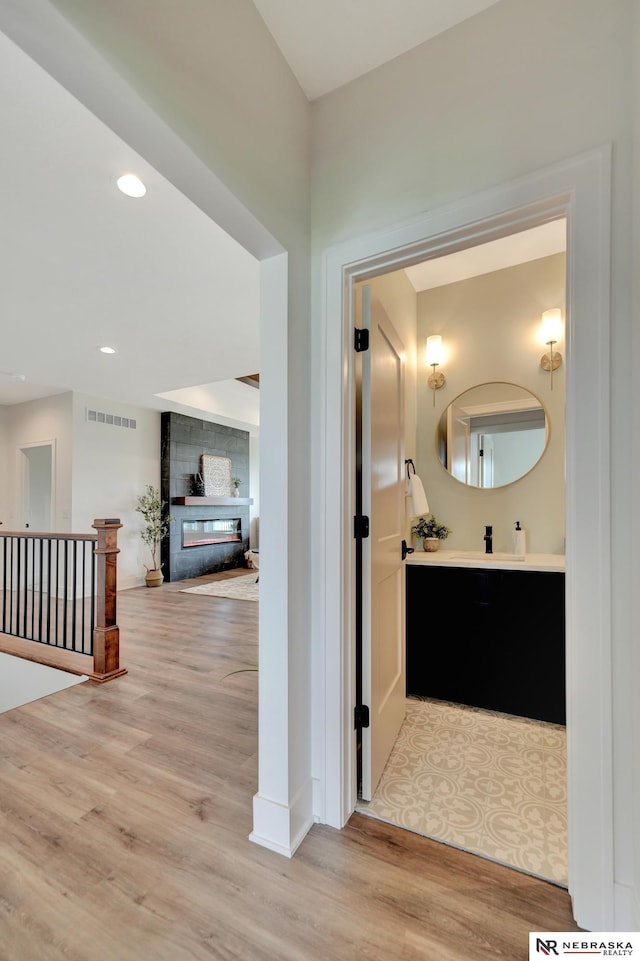 612 N 107th St, Lincoln, NE 68527 - hall featuring wood finished floors, a sink, baseboards, and recessed lighting